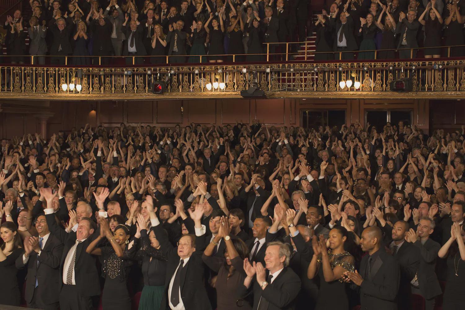 A theater audience on its feet, applauding
